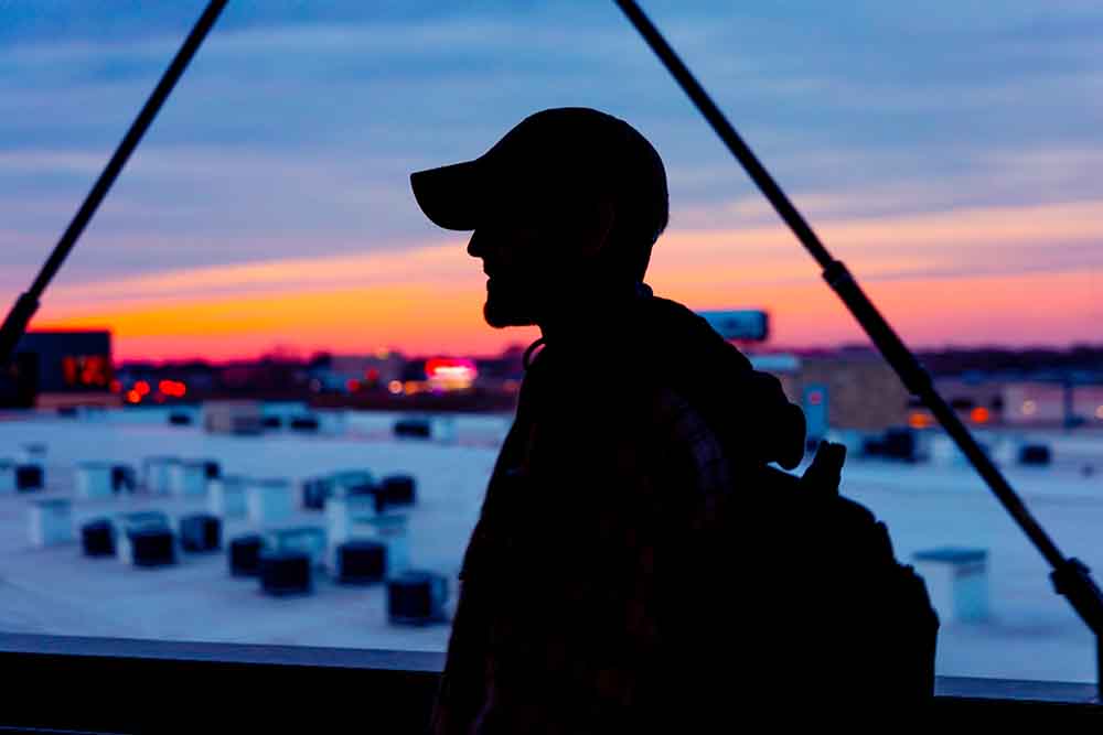 Silhouette of a man standing in front of vibrant sunset