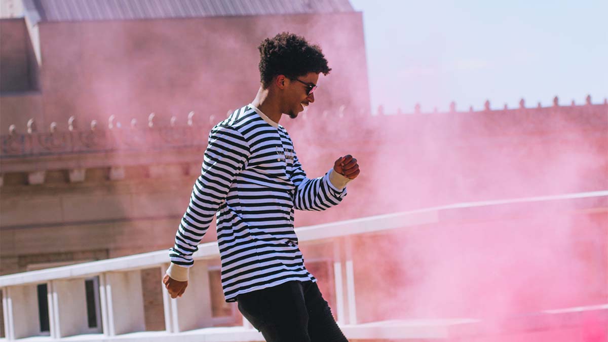 Guy dancing smoke bomb behind him